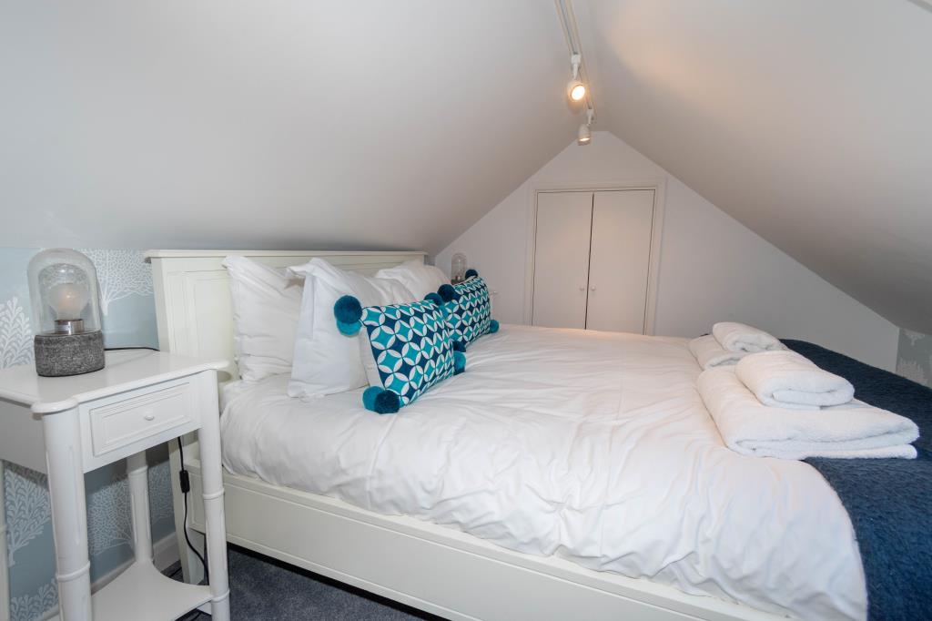 Lot: 29 - CHARACTERFUL FLAT IN A DESIRABLE NORFOLK COASTAL TOWN - Gallery Bedroom with restricted headroom and storage area